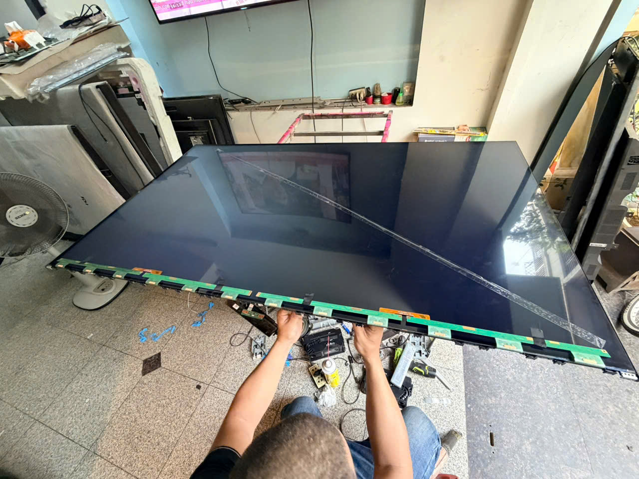 Thợ kỹ thuật tiến hành bóc seal thay màn hình tivi Samsung trực tiếp tại nhà khách hàng ở Hà Nội